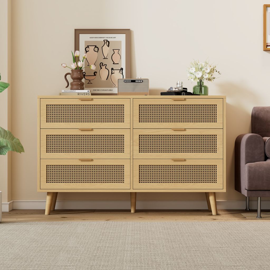 A wooden dresser with cane-woven drawer fronts sits in a living room setting.