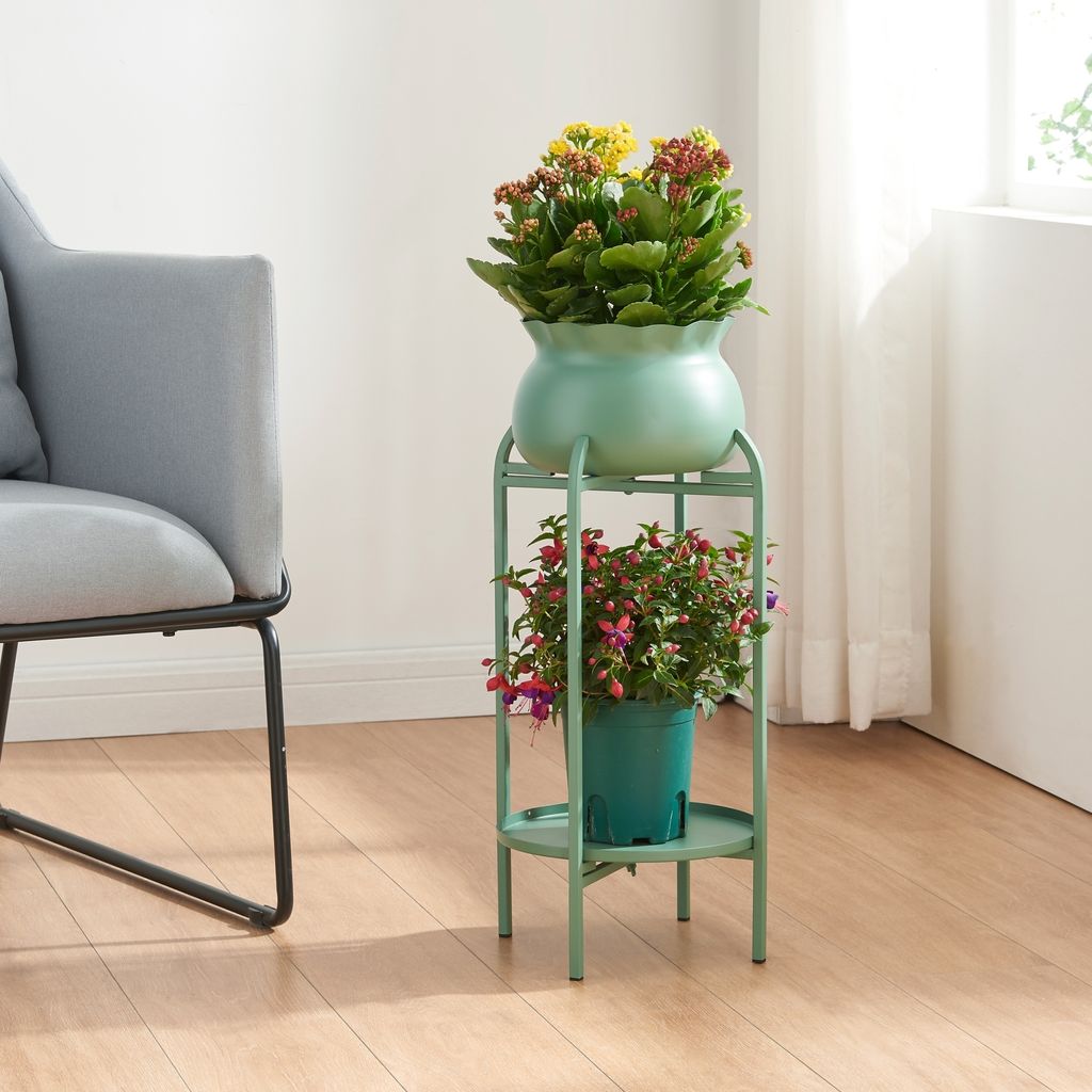 A plant stand with two potted plants next to a chair in a room.