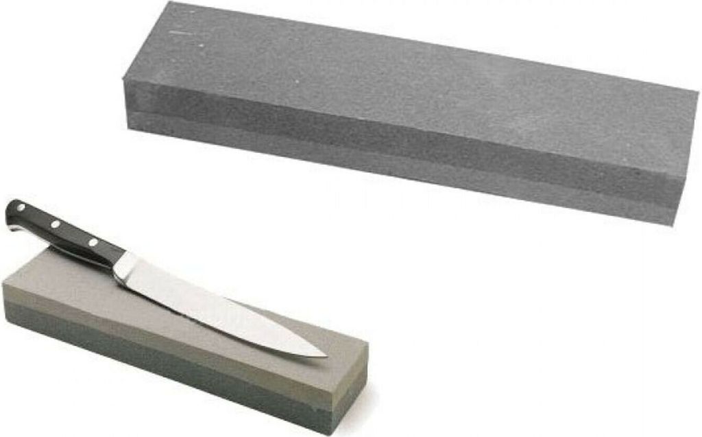 A knife sharpening stone with a knife on it, and another sharpening stone above.