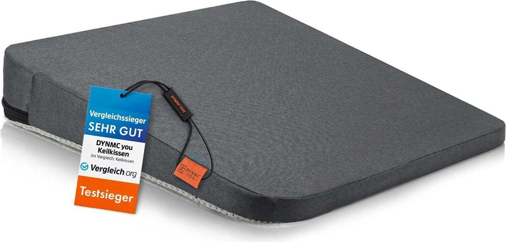 A gray wedge-shaped cushion with tags attached.