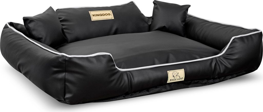 A black dog bed with white trim and two small pillows, shown from a slightly elevated side angle on a white background.