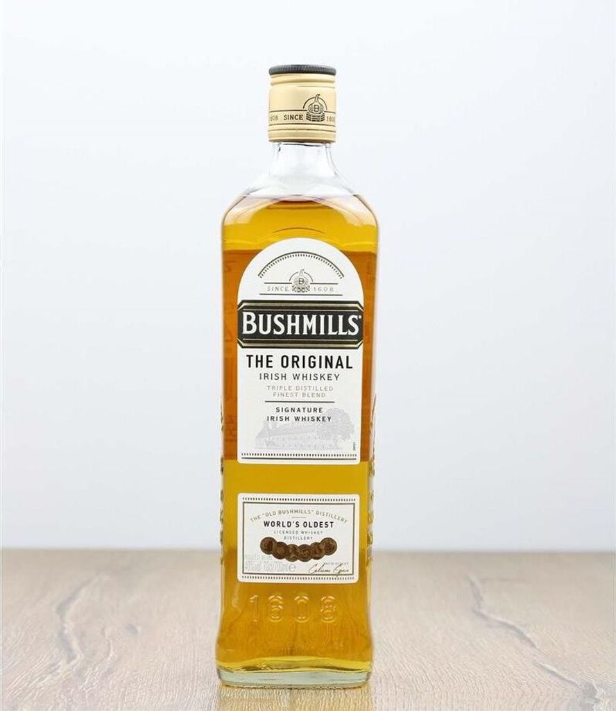 A bottle of Bushmills Original Irish Whiskey on a wooden surface.