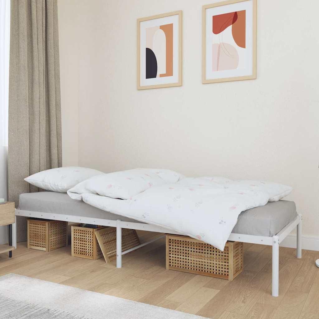 A bedroom scene with a white metal bed frame, white bedding, and two framed abstract art pieces on the wall.