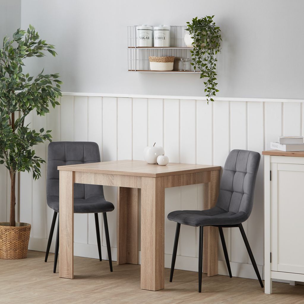 A dining set with a table and two chairs in a room.