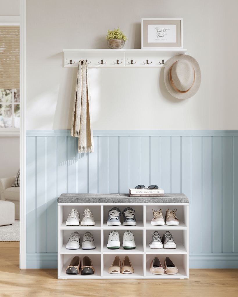 An entryway with a shoe bench and a wall-mounted shelf with hooks.