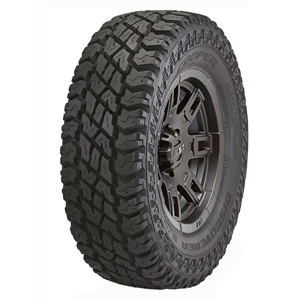 A close-up studio shot of a Cooper Discoverer ST Maxx tire mounted on a black wheel, isolated on a white background.