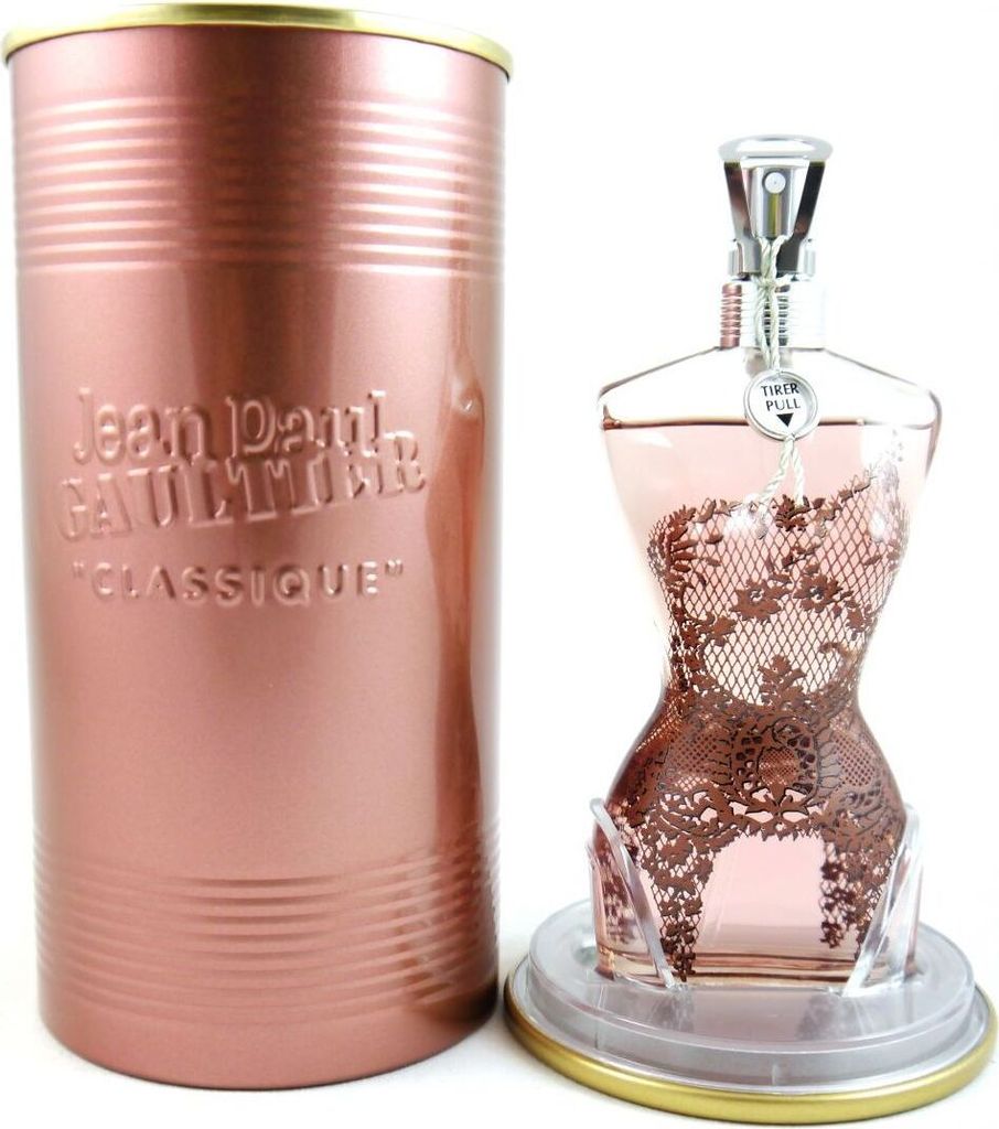 A perfume bottle and its cylindrical tin packaging are displayed against a white background.