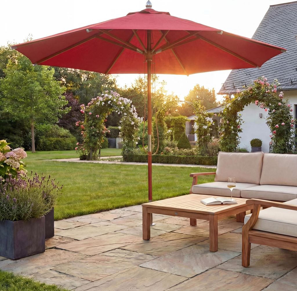 A garden patio with outdoor furniture and a large red umbrella.