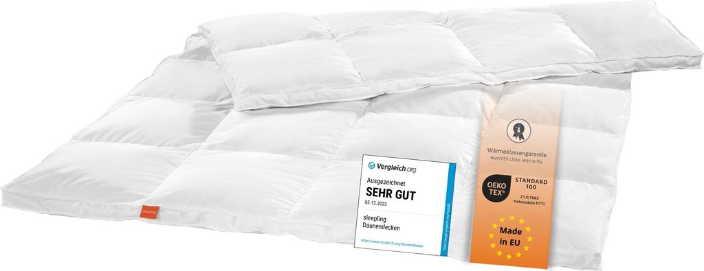 A white down comforter is laid out on a white surface, with tags attached.