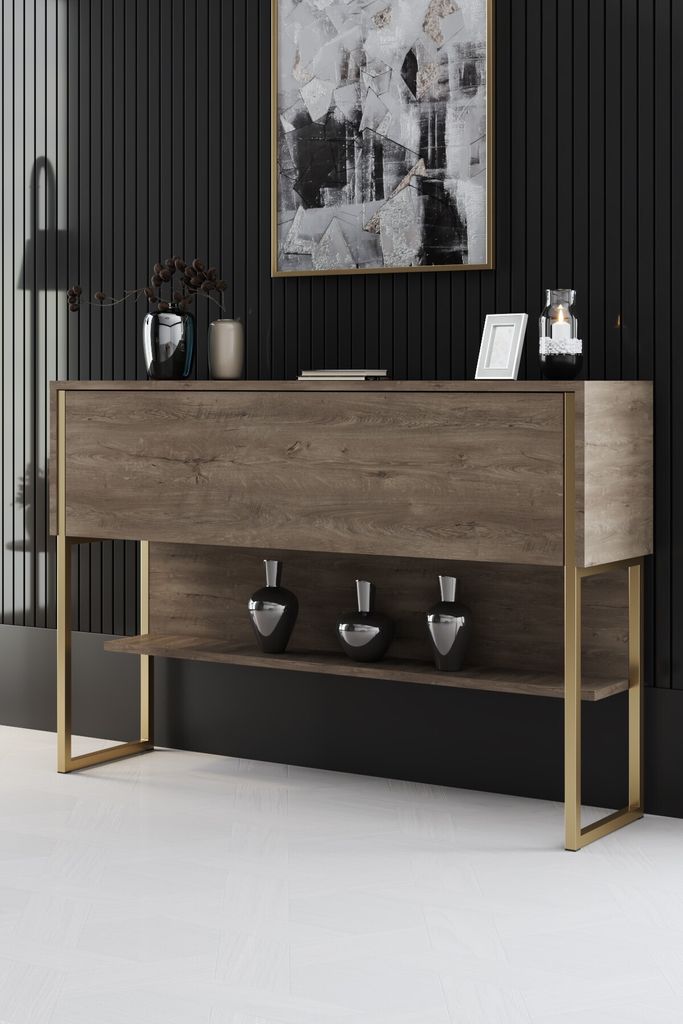 A modern console table with a walnut finish and gold metal legs, decorated with vases and a framed picture.