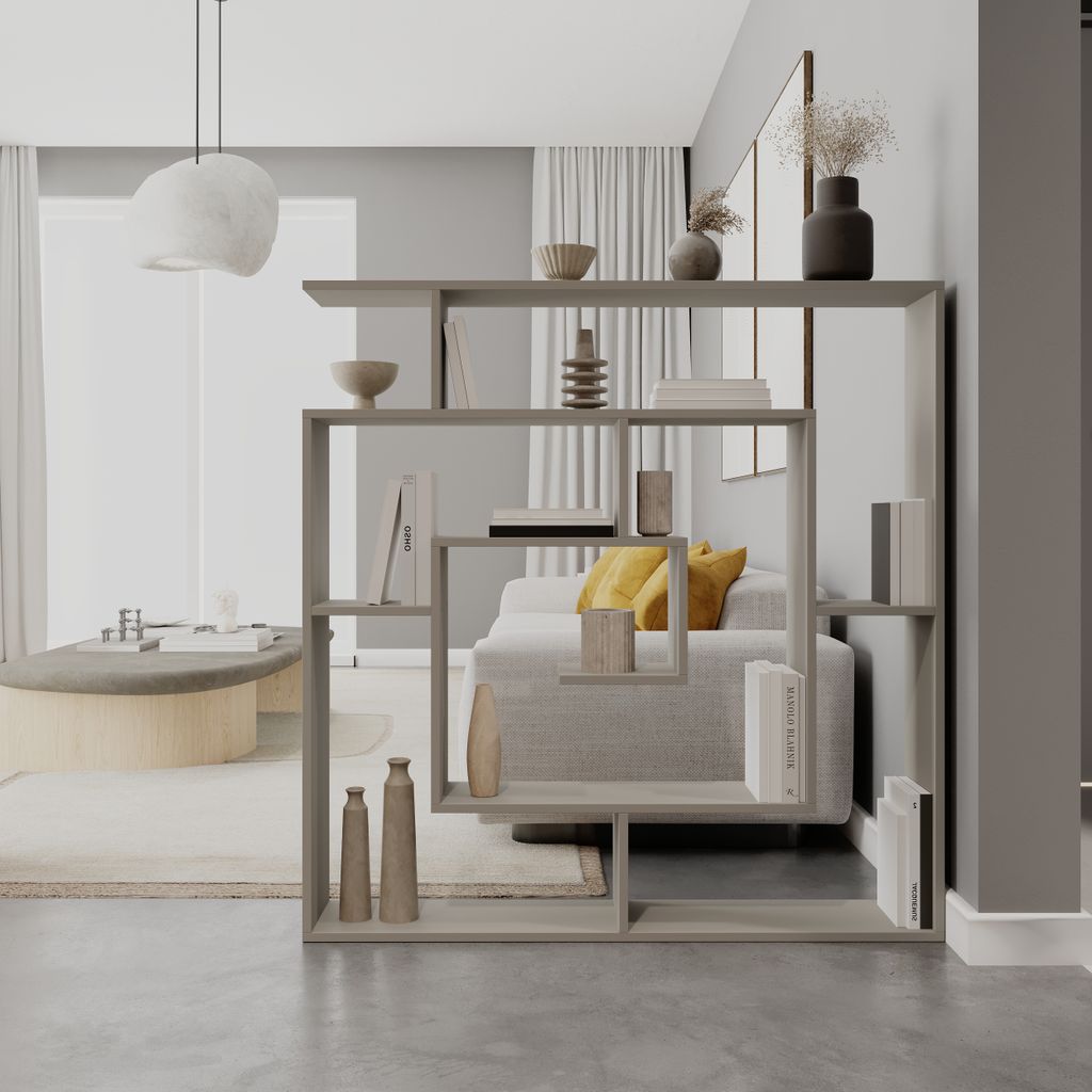 A modern living room with a bookshelf room divider, sofa, and coffee table.