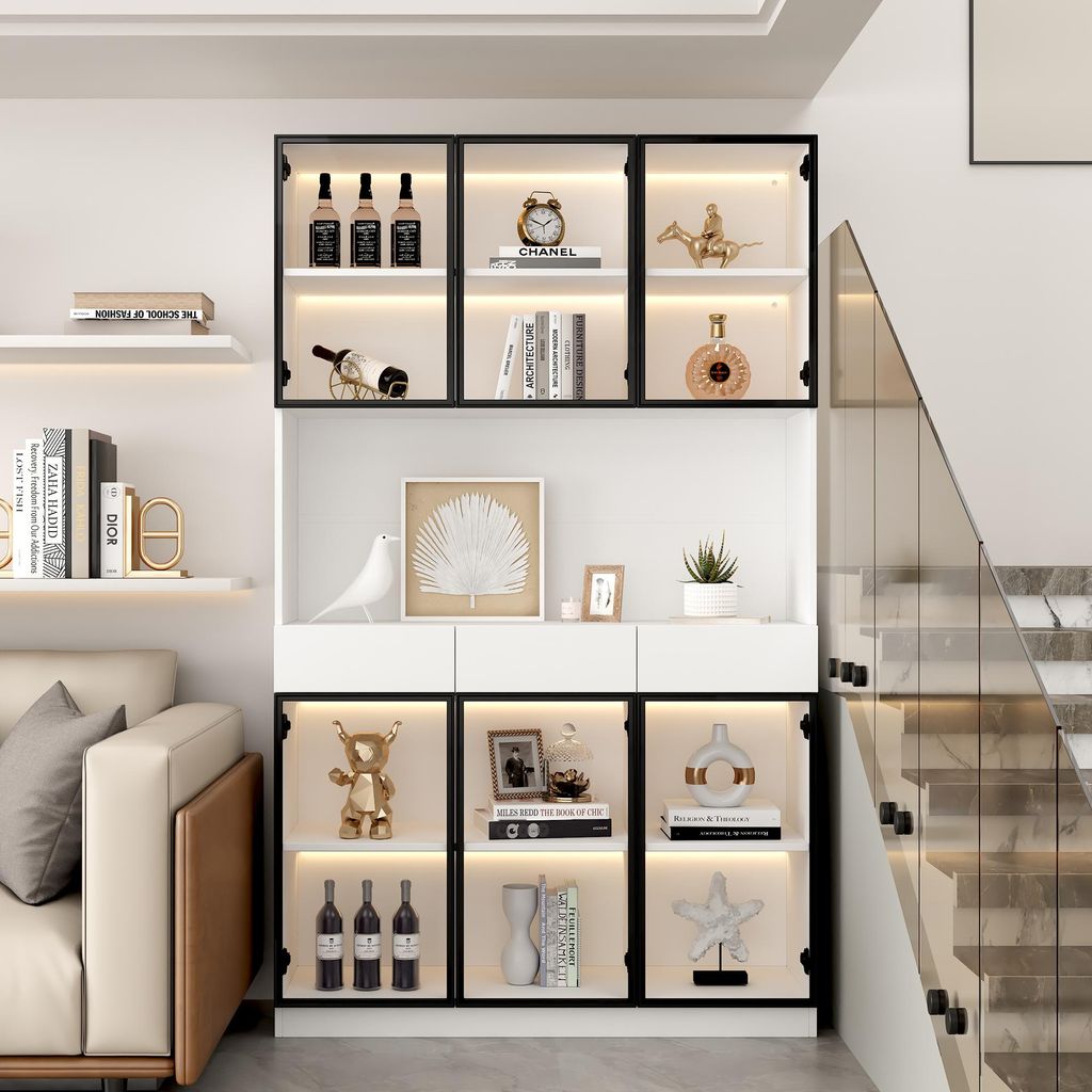 A modern living room with a display cabinet filled with decorative items and bottles, next to a sofa and a staircase.