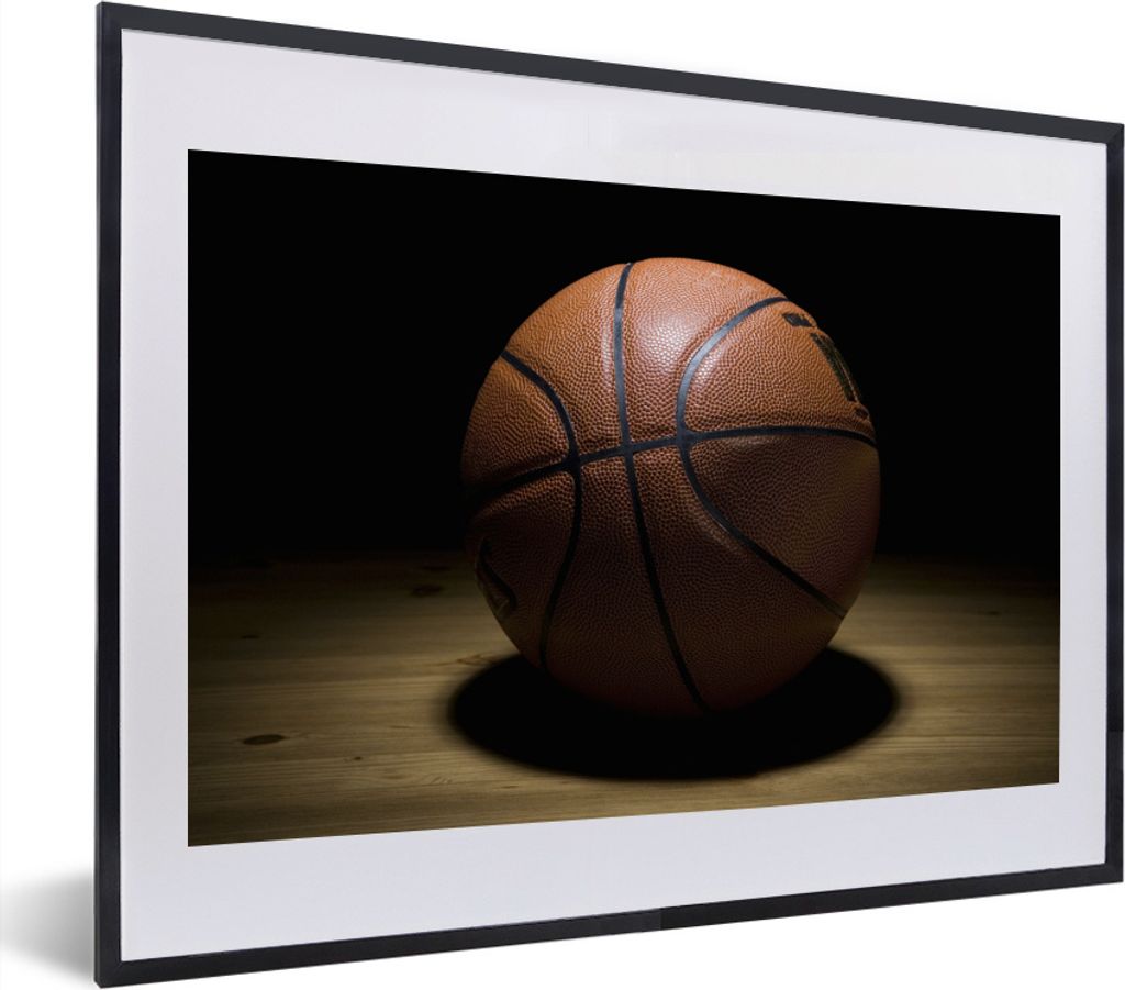 MuchoWow MuchoWow Gerahmtes Poster Ein Basketball im Scheinwerferlicht in einer Halle 40x30 cm - Poster mit zchwarzem Bilderrahmen - Bilderrahm...