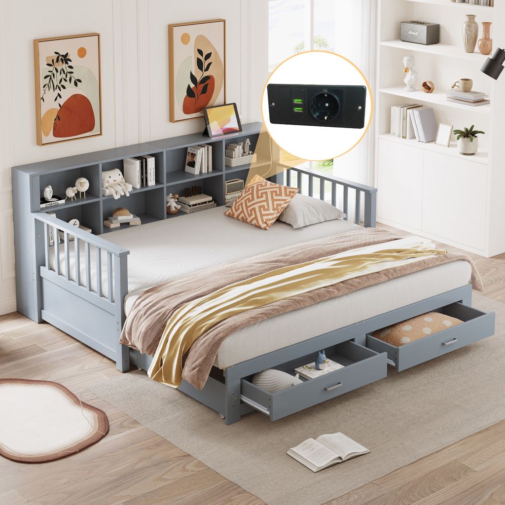 A daybed with storage drawers and a bookshelf headboard, set in a bedroom with artwork on the wall and a bookshelf in the background.