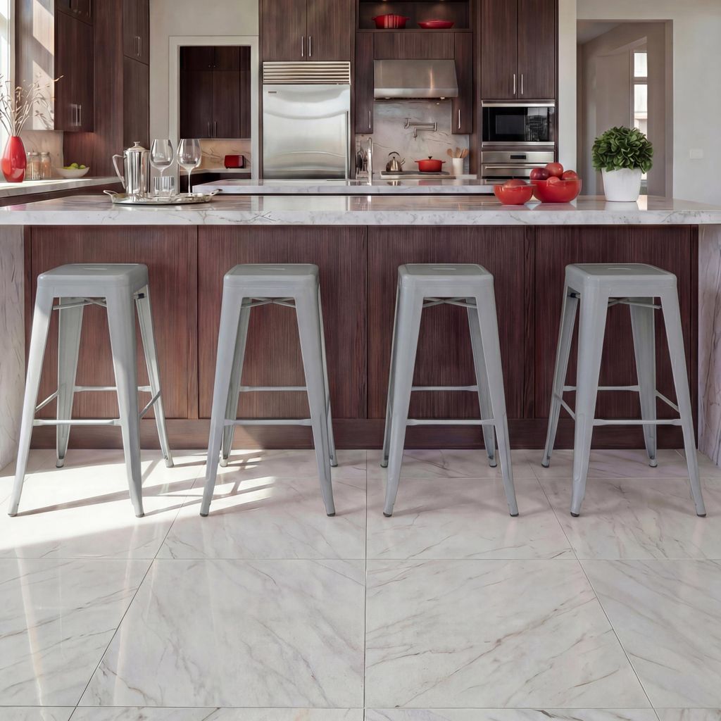 A modern kitchen island with four gray metal bar stools.