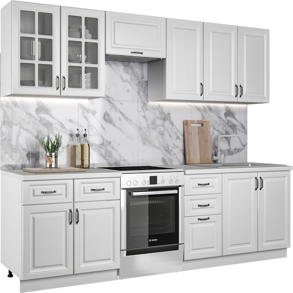 A white kitchen unit with cabinets and an oven, set against a marble-patterned backsplash.
