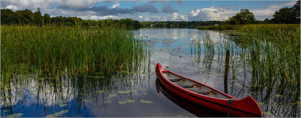 Wallario Poster - Rotes Kanu am See, Kunstdruck Größe: 50 x 125 cm