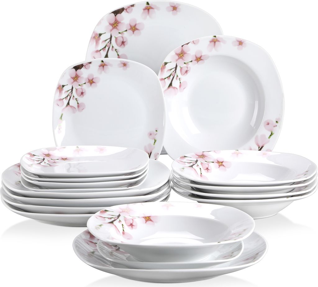 A collection of white porcelain dinnerware with a pink cherry blossom pattern.