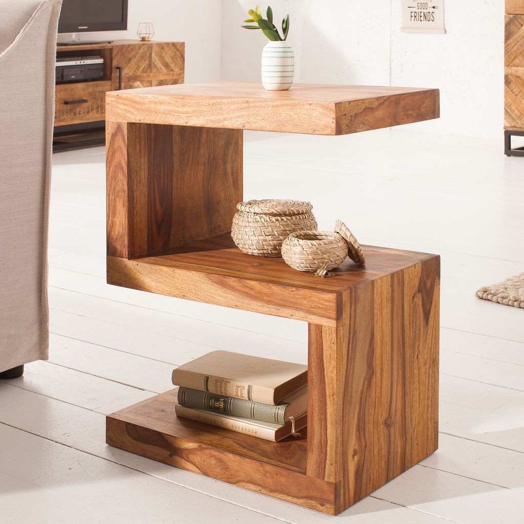 A wooden side table with books and baskets on it, placed on a white floor.