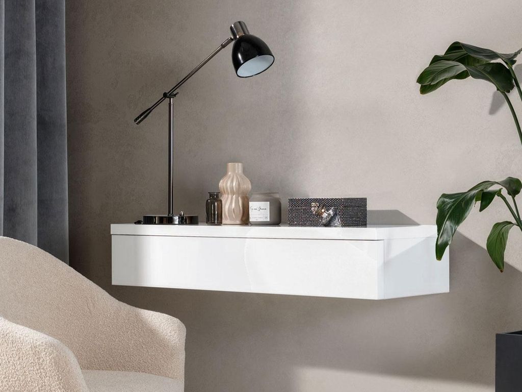A modern living room setting with a floating shelf, a lamp, and a plant.