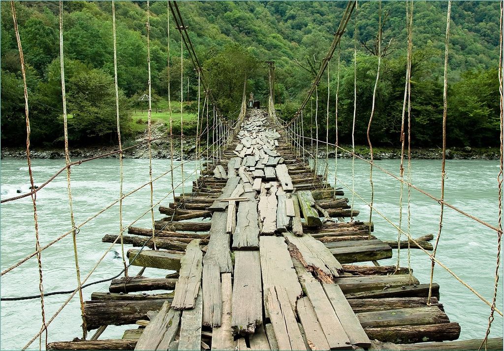 Wallario Fototapete Vliestapete, seidenmatte Oberfläche, einfache Verarbeitung, Größe 200 x 140 cm, Motiv Alte Hängebrücke über dem Fluss