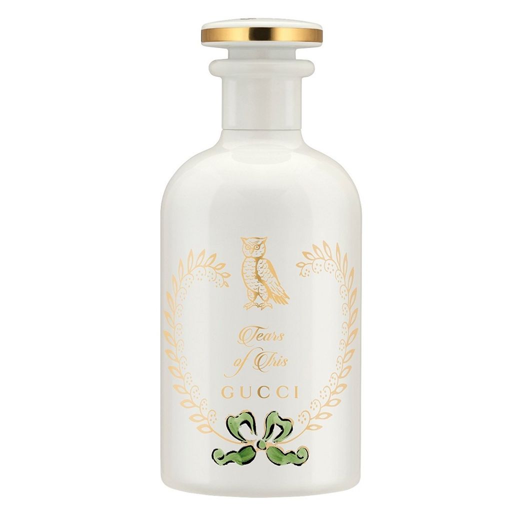 A white perfume bottle with gold and green accents.