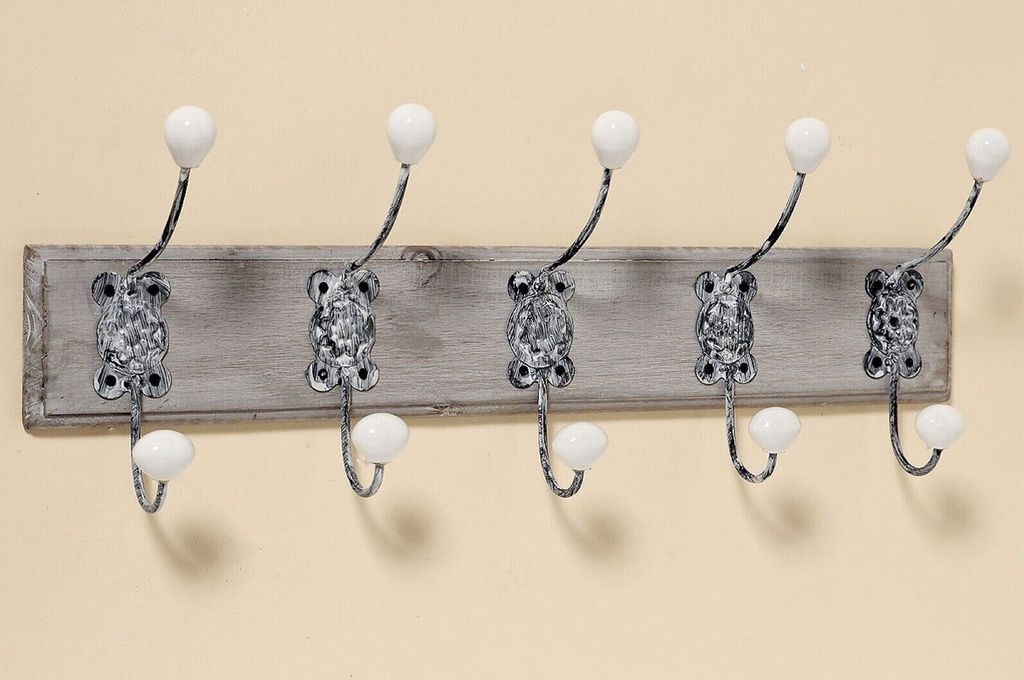 A wall-mounted coat rack with five hooks.