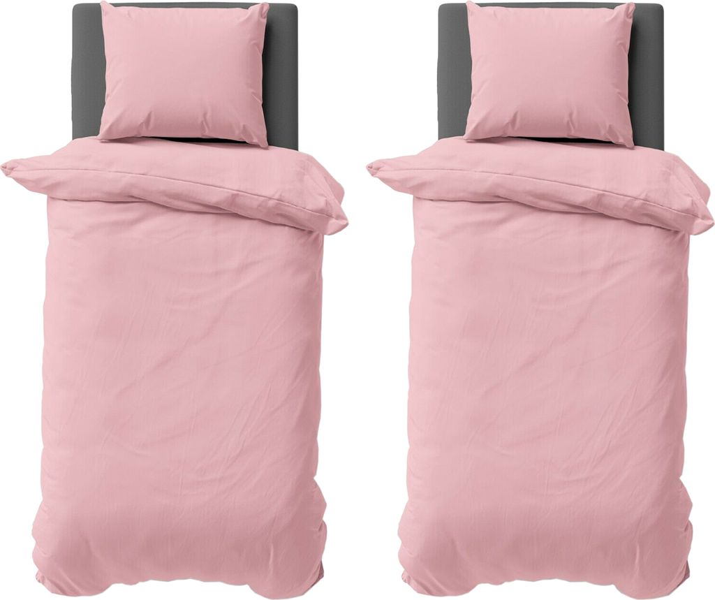 Two identical pink duvet covers and pillowcases are laid out on beds with grey headboards.