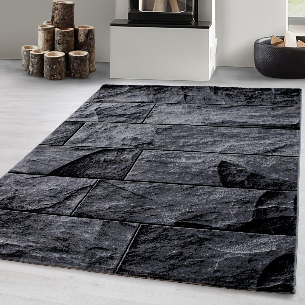A rug with a stone pattern is placed on a light gray floor in front of a fireplace.