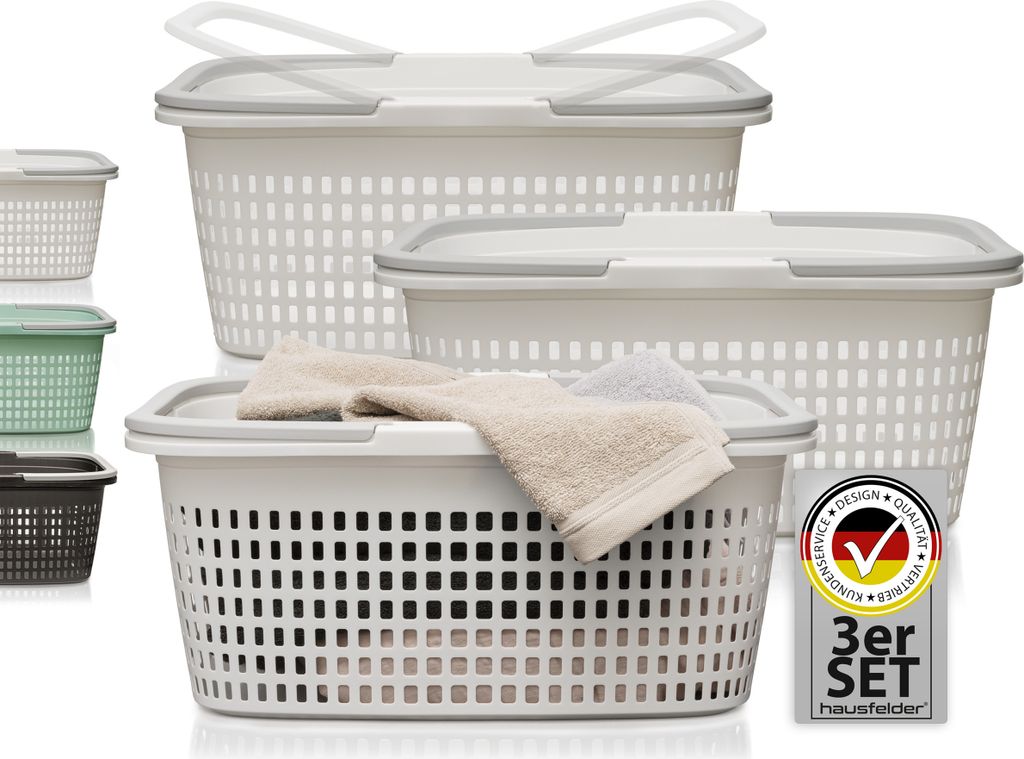 A set of three white laundry baskets with gray lids and handles, stacked and arranged on a white background. Smaller baskets in green and brown are visible on the left.