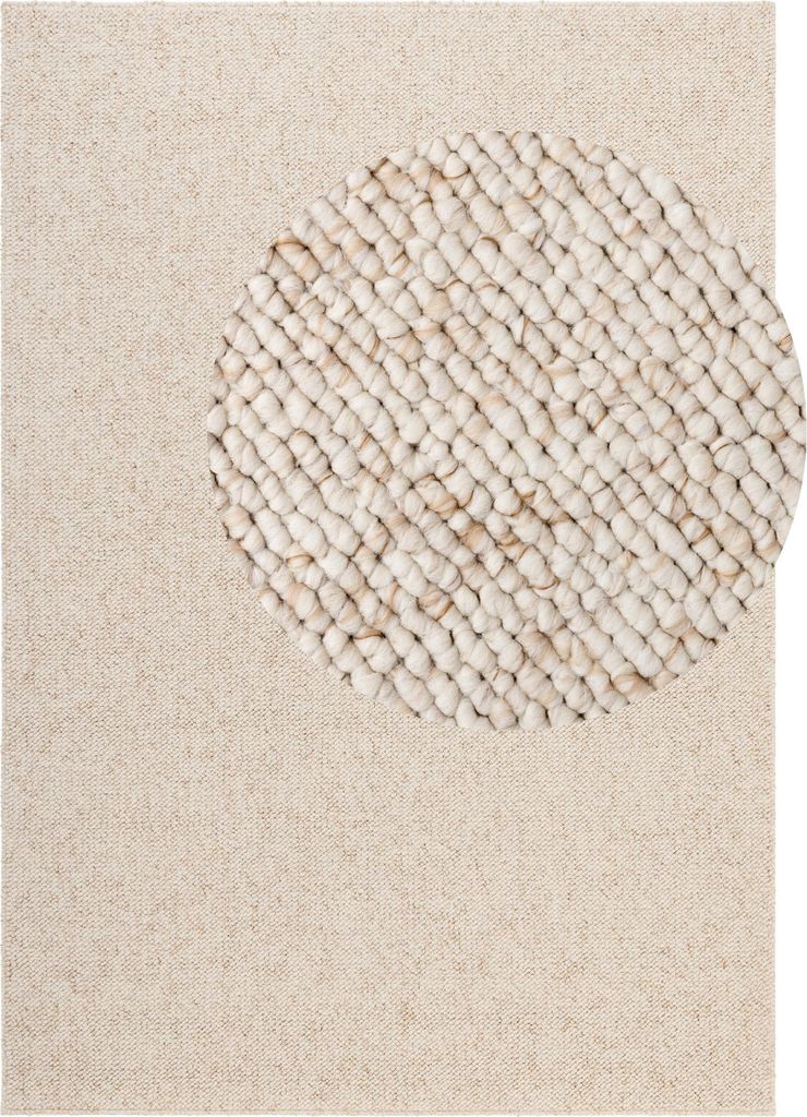 A close-up view of a cream-colored rug with a textured circular pattern.