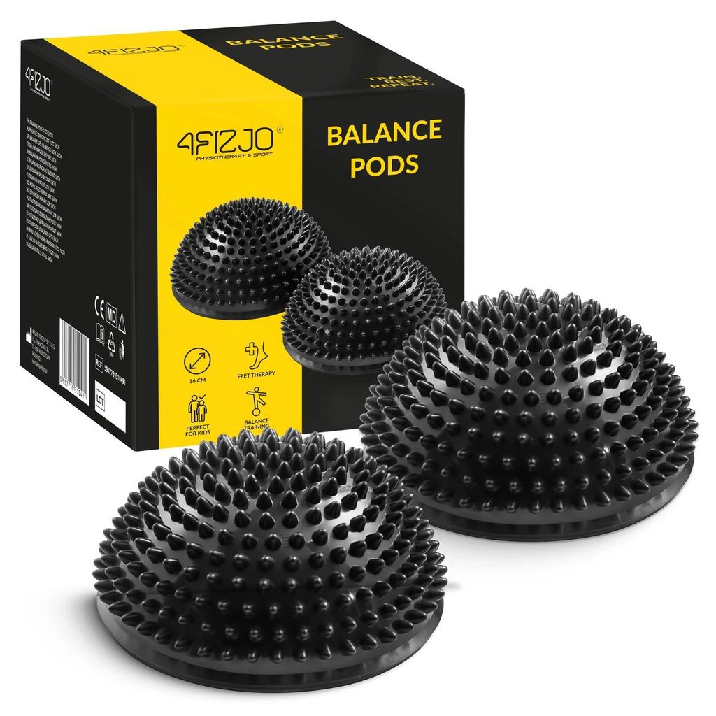 A product shot of two black balance pods with spikes, placed in front of their packaging.