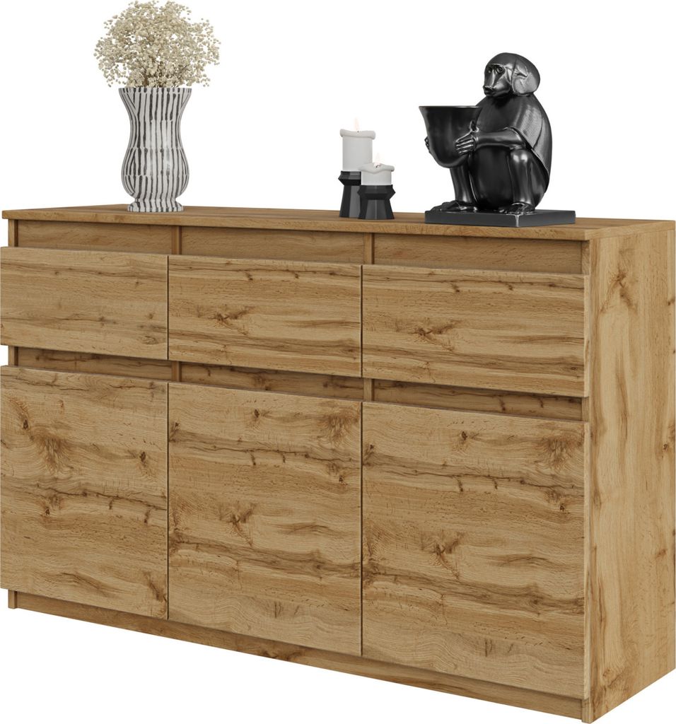 A wooden sideboard with three drawers and three doors, decorated with a vase of flowers, two candles, and a monkey statue.