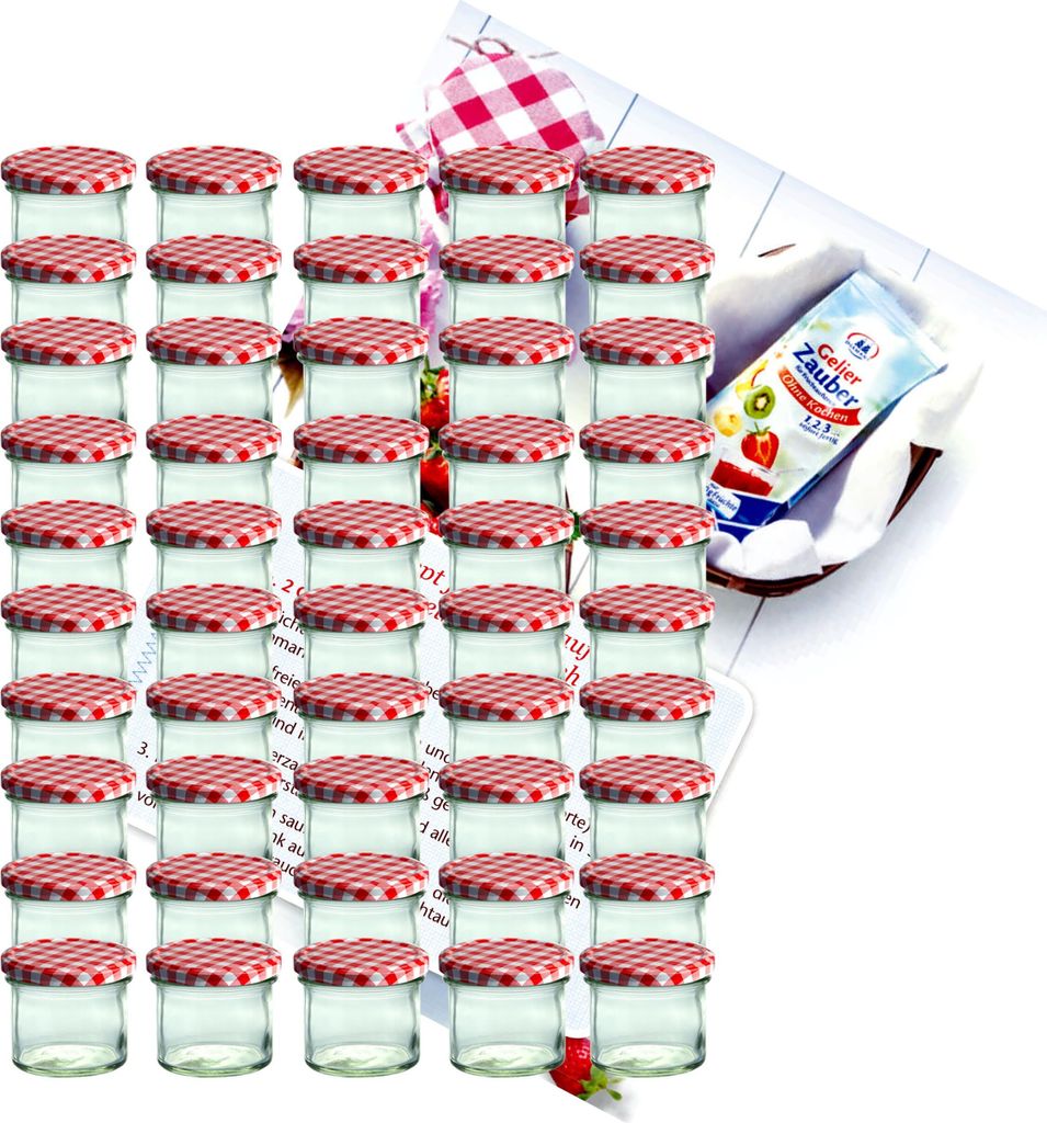 A large group of small glass jars with red and white checkered lids, arranged in rows. A small packet with text and images of fruit is visible in the background.