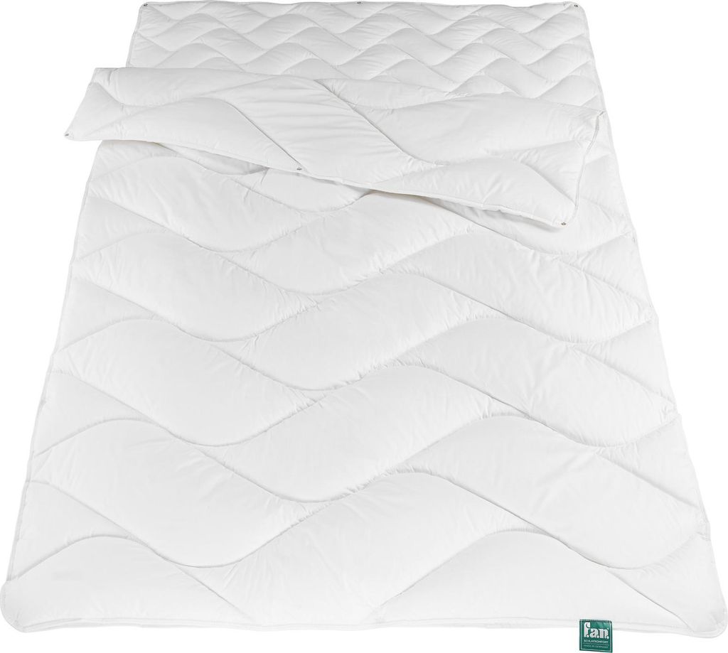 A white duvet is laid out flat on a white background, with a portion folded over.
