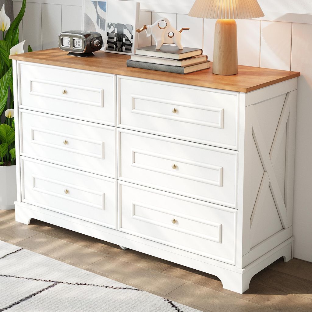 A white and wood dresser with six drawers is shown in a room setting, with a plant and decor on top.