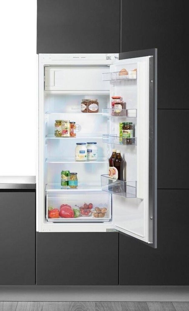 An open refrigerator with food items inside, set against a dark gray kitchen background.