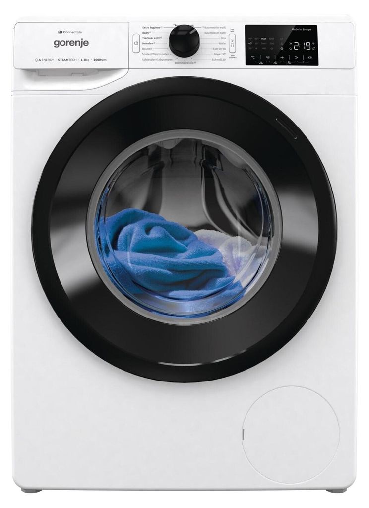 A front-facing studio shot of a white washing machine with a black door rim. Blue laundry is visible inside the drum.