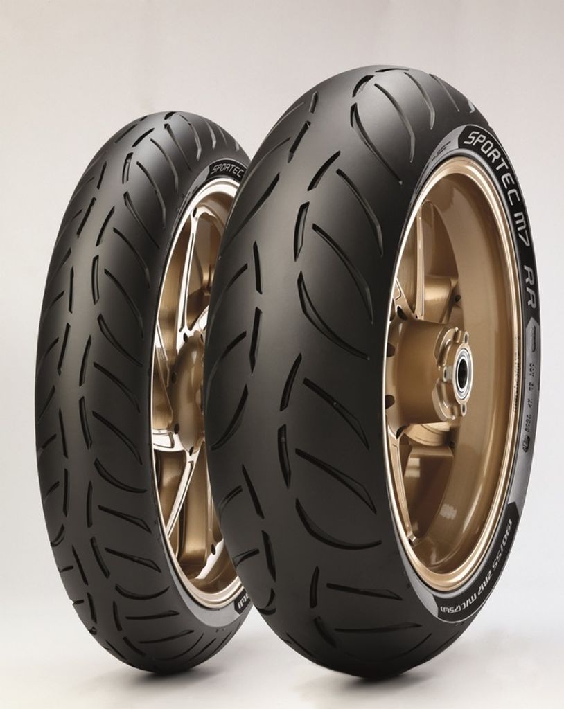 Two motorcycle tires mounted on gold rims, displayed against a white background.