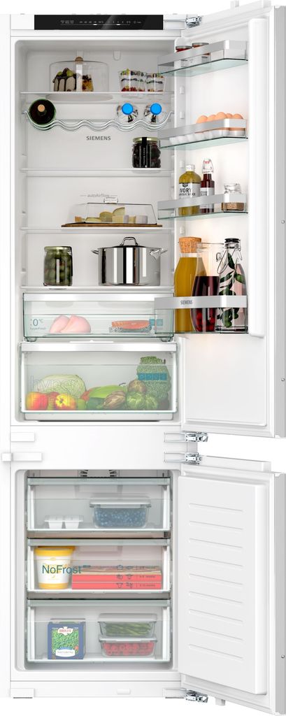 An open built-in refrigerator and freezer combination, showing the interior shelves and drawers stocked with food items.