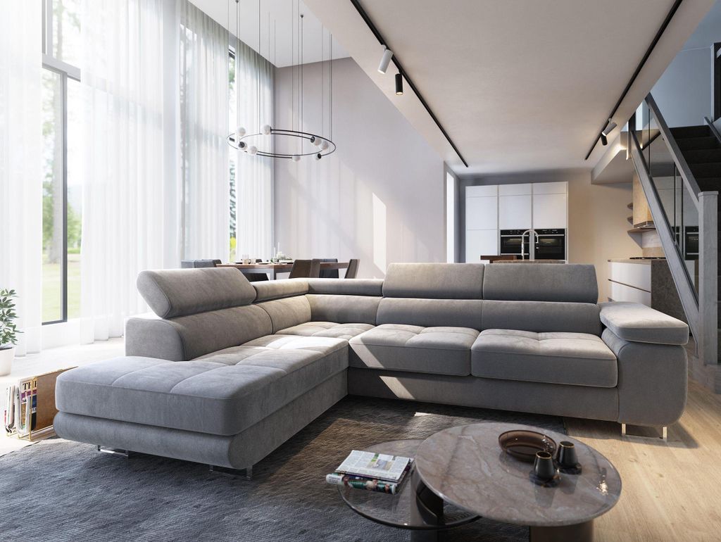 A modern living room with a large sectional sofa, coffee table, and a view of a dining area and kitchen.