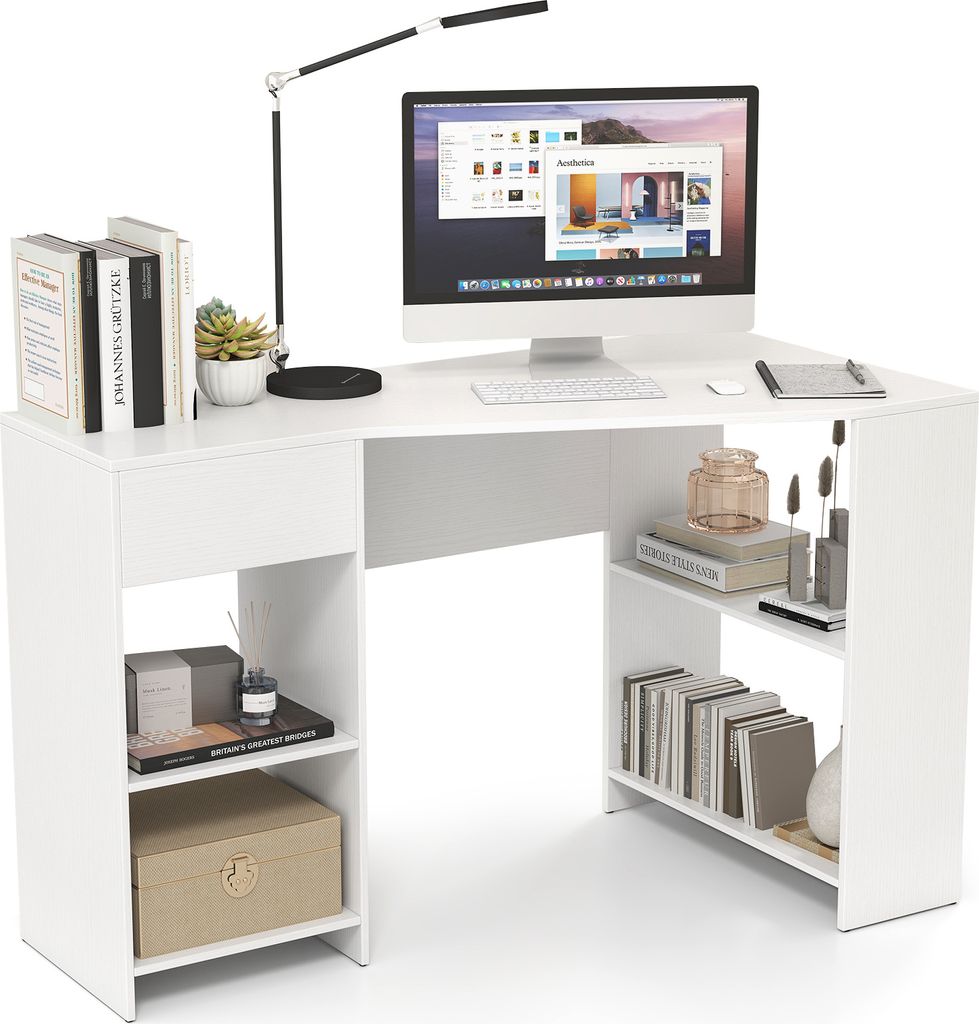 A white L-shaped desk with a computer, lamp, books, and decorative items.