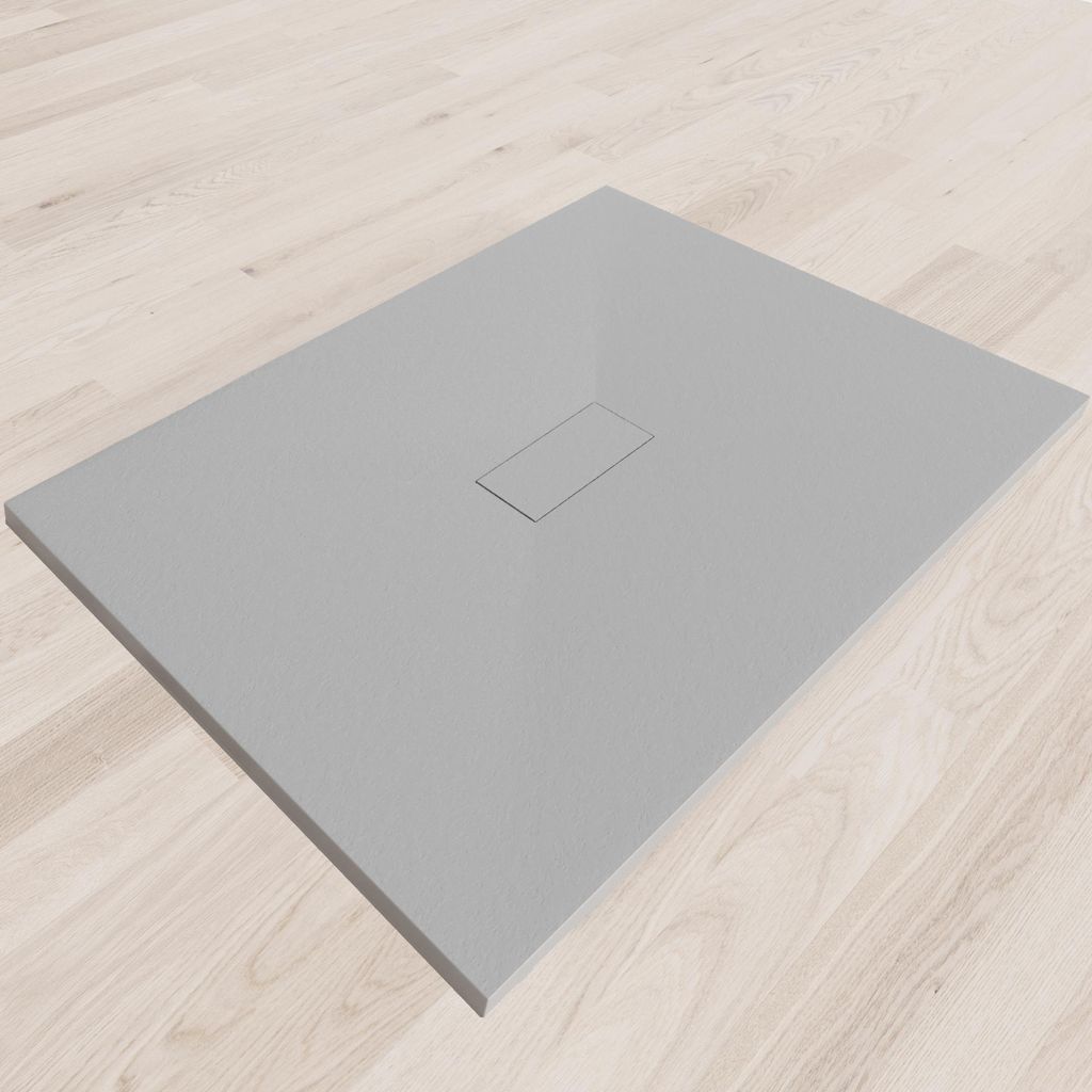 A flat, gray shower tray with a central drain cover, placed on a light wooden floor.
