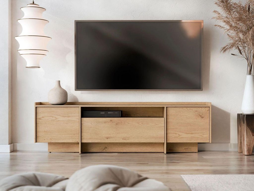 A modern living room with a TV stand and a large television mounted on the wall.
