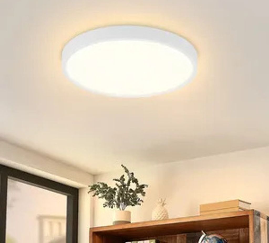 A white, circular LED ceiling light is mounted on a white ceiling.