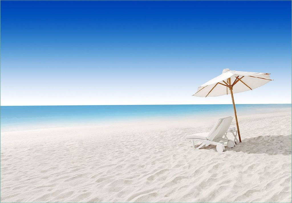 Wallario Fototapete Vliestapete, seidenmatte Oberfläche, einfache Verarbeitung, Größe 200 x 140 cm, Motiv Sonnenliege am weißen Strand unter bl...