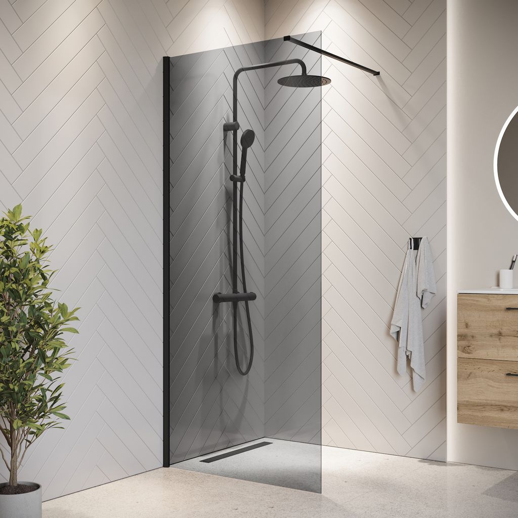 A modern bathroom with a walk-in shower, vanity, and plant.