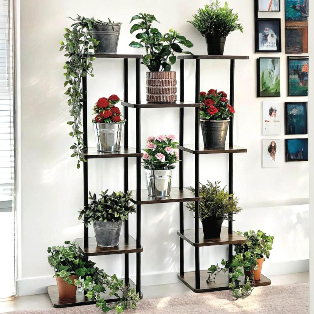 A multi-tiered plant stand with various potted plants displayed on its shelves, set against a white wall.