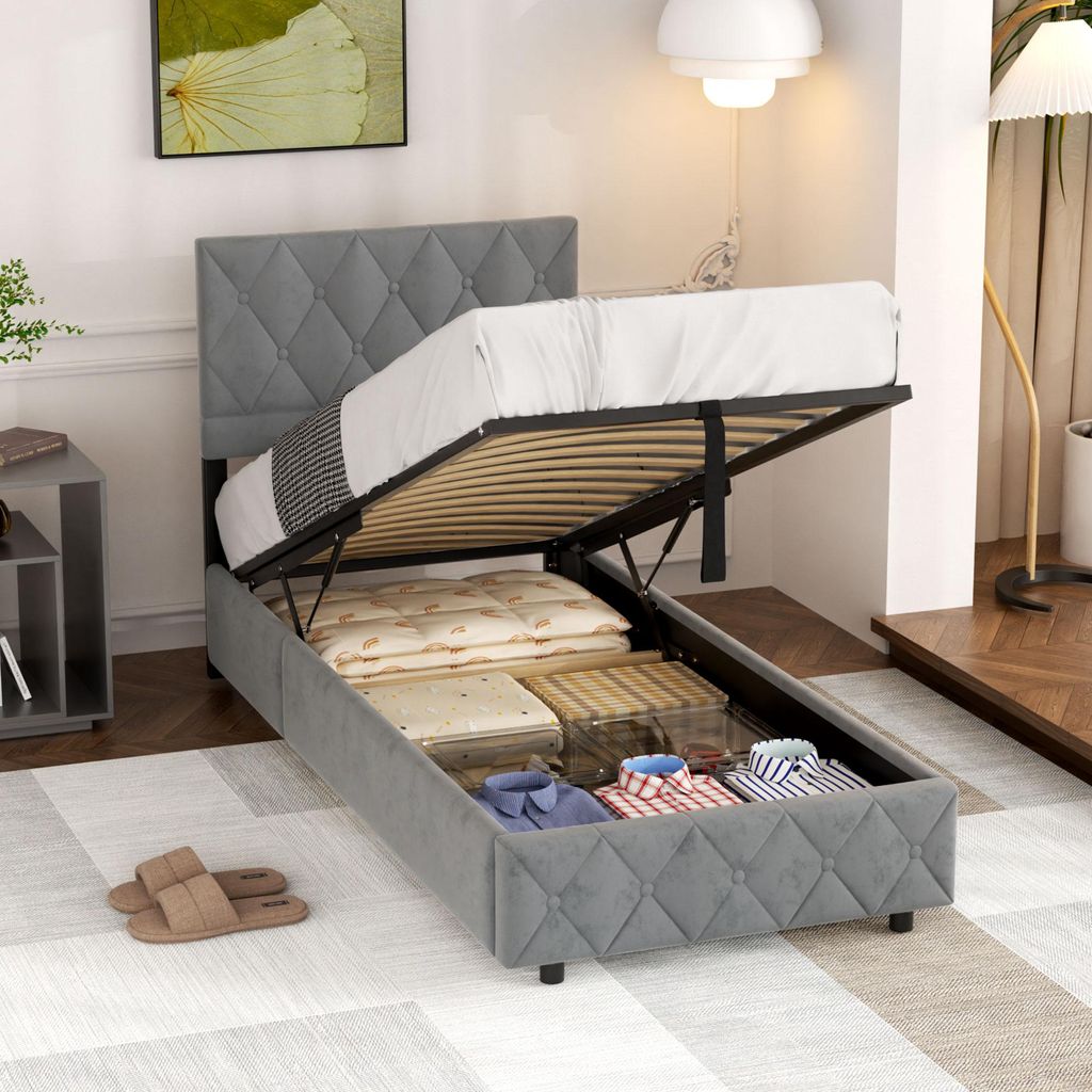 A bed with its storage compartment open, revealing stored items.