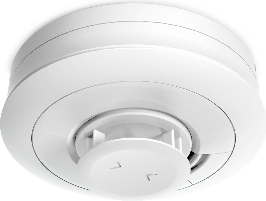 A white smoke detector mounted on a white ceiling.